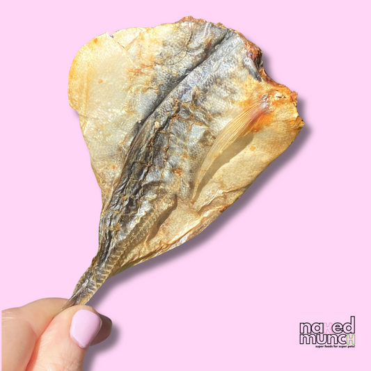 Dried fish held by a hand against a pink background with 'na ed munc' branding.